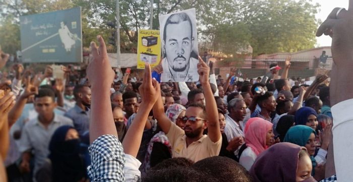 Protesters hold an image of teacher Ahmed al-Kheir, tortured and killed by Sudanese security forces - image: SPA via Facebook